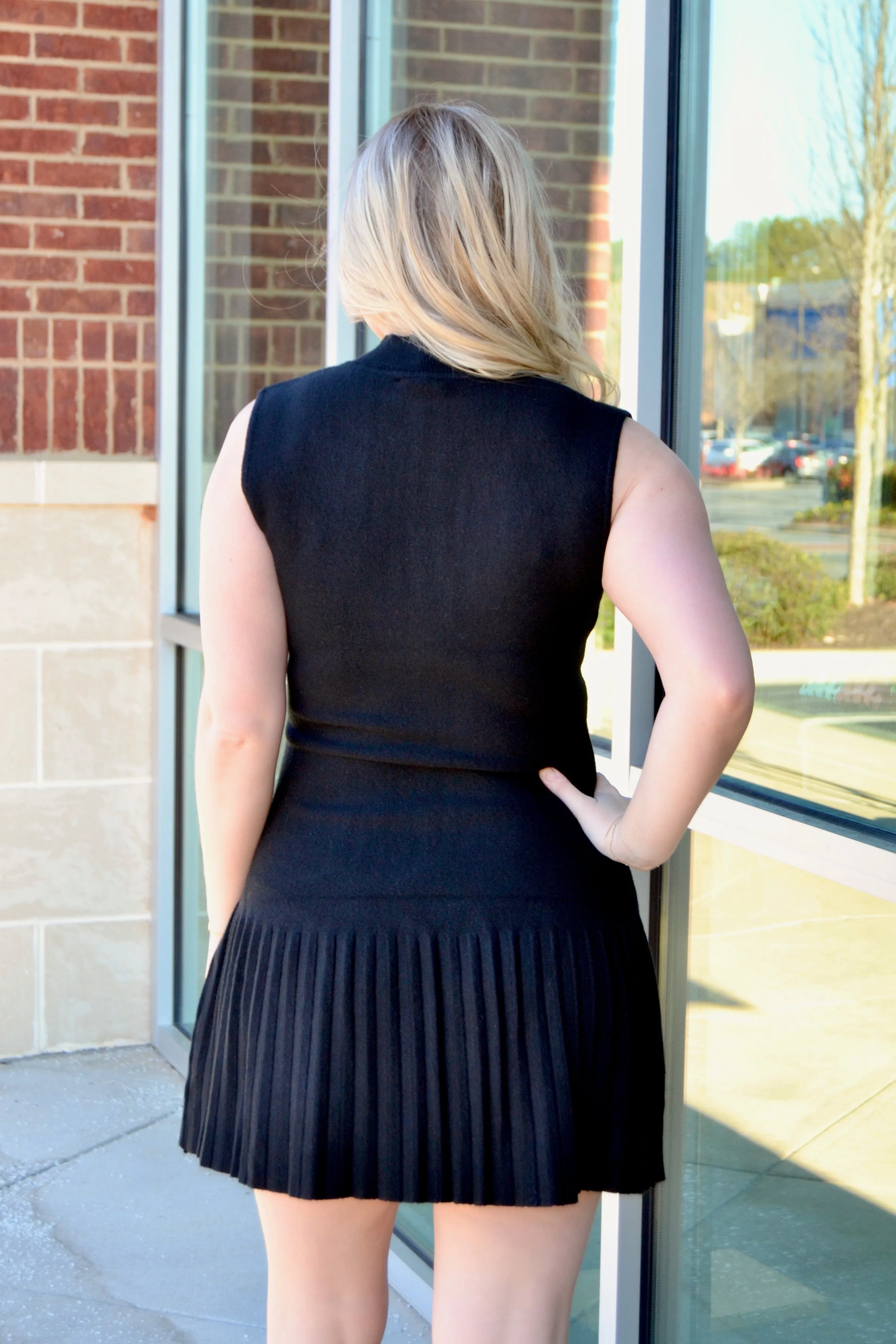 Black sleeveless pleated dress